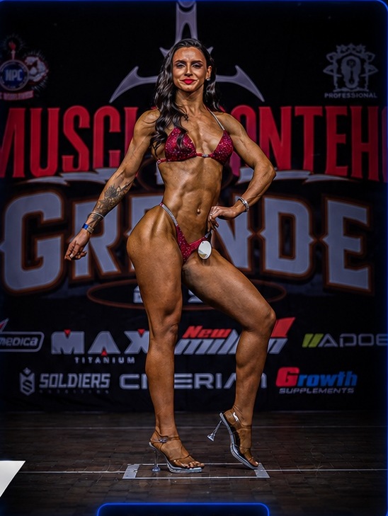 Atleta em apresentação no palco de fisiculturismo